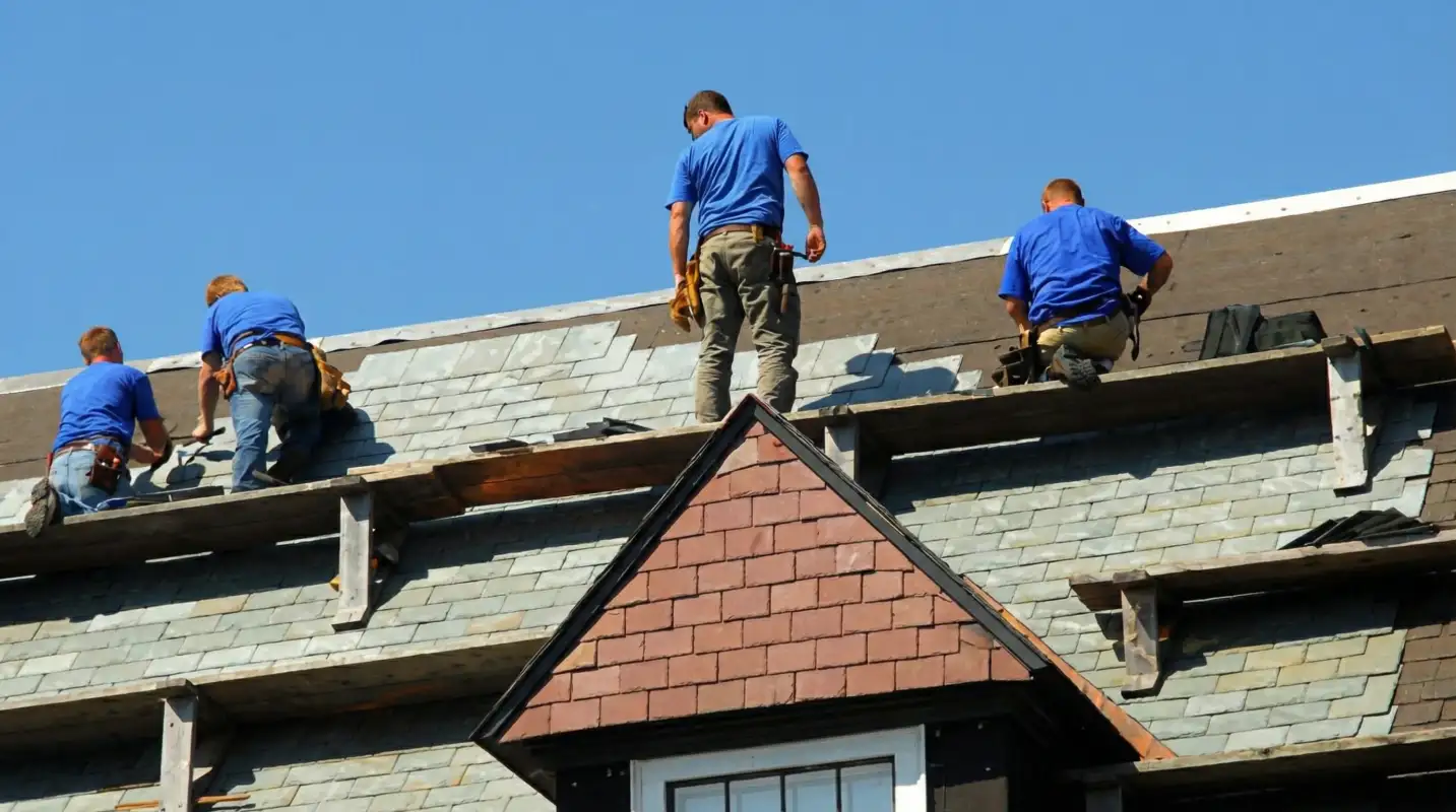 Roof replacement in progress with a team of professional contractors installing new shingles on a residential home in Erie, PA