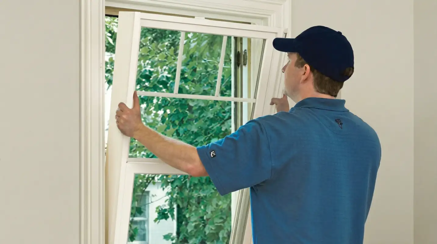 Professional contractors performing a residential window insulation and replacement service in Erie, PA